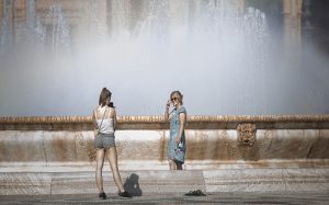 Dos mujeres junto a la fuente de la Plaza de España, en Sevilla.